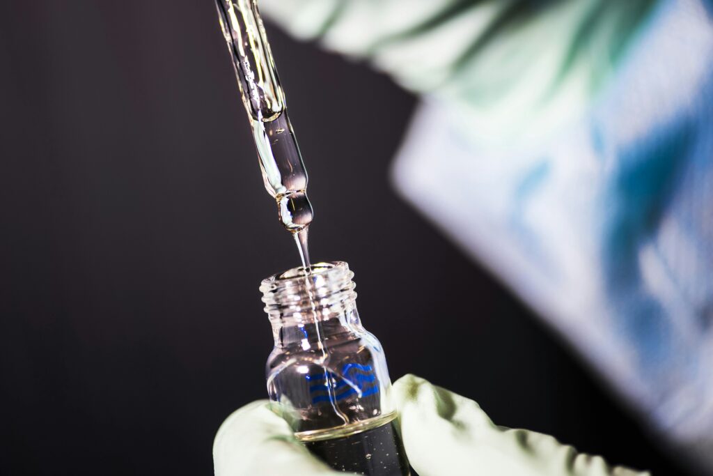 A microbiologist in gloves pipetting a sample into a vial in the MSI laboratory